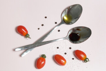 Summer salad ingredients - Freshly harvested cherry tomatoes, spoon of vinegar and olive oil, salt and pepper