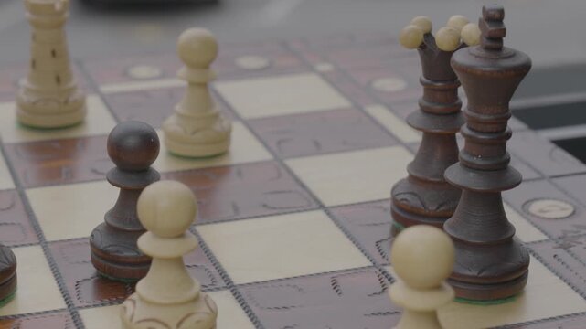 hand of man moving a chess piece on a board