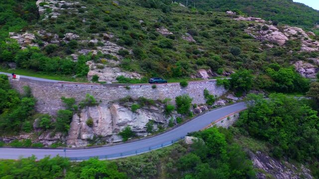 Drone view of serpentine asphalt road in mountainous area in Italian Alps. cars are going on a trip. Green planet. Tourism. Transport. Dangerous road. Italy Bergamo 24.08.2025