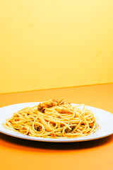 A generous serving of spaghetti bolognese topped with a mound of shredded cheese and herbs.