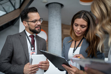 Business people discussing work using digital tablet and clipboard