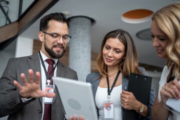 Business people using tablet and discussing during conference or meeting