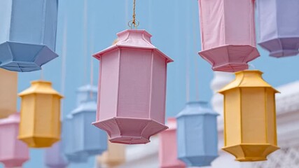 Lanterns hanging outdoors, festive paper lanterns against clear sky, decorative lanterns used in celebrations & festivals paper lanterns in pastel shades, cultural decor for events, hanging lanterns