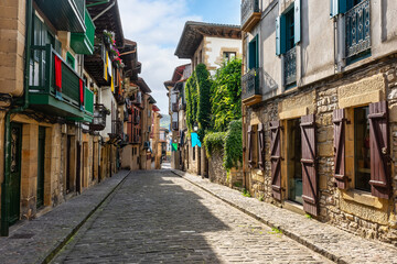 Fototapeta premium Typical cobbled streets with wooden balconies with flowers in the picturesque village of Hondarribia, Basque Country, Spain.