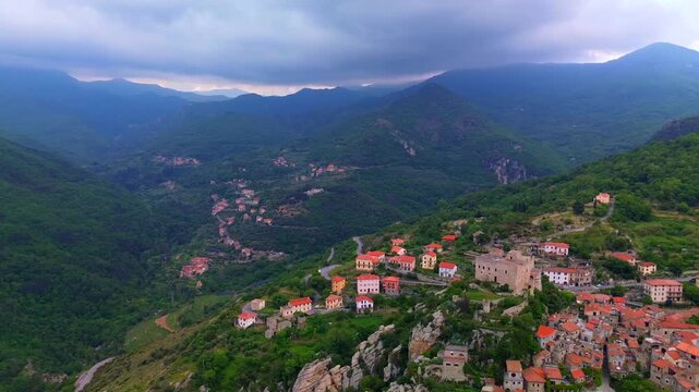 Aerial view of the ruins of an ancient castle, a medieval village on a hill near the Neva River valley and built for defensive purposes, history. Castelvecchio di Rocca Barbena Savona Italy 01.09.2025