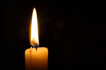 Candle burns in a dark room