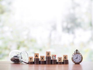 Vintage watch,  Wooden blocks with the word TAX, Nunber 2025 and stack of coins. The concept about...