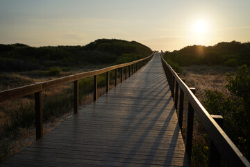 Wooden Boardwalk over the sand dunes on the way to Sao Jacinto Beach at sunset