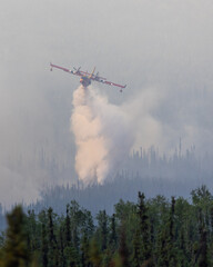 Airplane dropping water on wildfire.