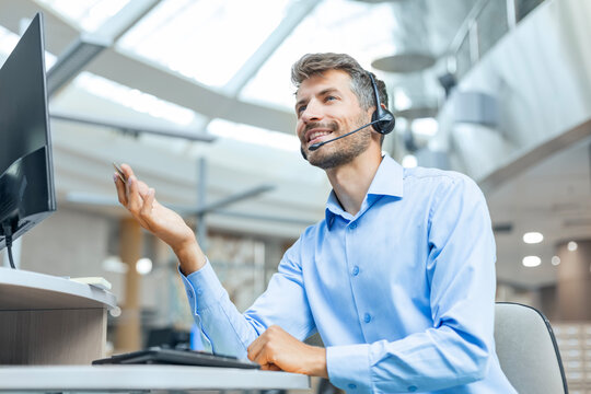 Smiling friendly handsome young male call centre operator.
