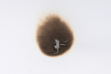 Paper burn black  stain. Round paper burn mark close up. burns borders paper close up