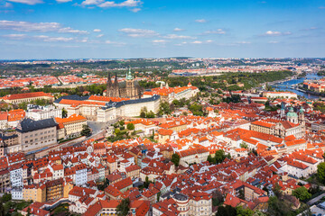 Panoramic view of Prague featuring historic castle and vibrant rooftops on a sunny day in summer. Aerial view of Prague, Czech Republic, showcasing the city's iconic architecture and red-tiled roofs.