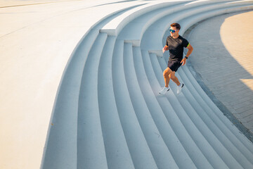 Running along curved steps in a modern outdoor space under bright sunlight
