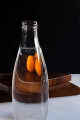 apricots and bottle of water with distortion on black background
