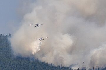 Airplanes drop water on a wildfire.
