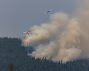 Airplanes drop water on a wildfire.