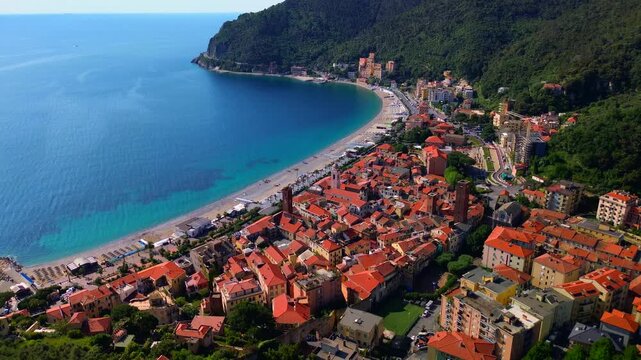 Beach and palm trees. Fishermen boats. Crystal clear blue sea water. Aerial view of a medieval settlement in Liguria. Seaside town with high towers. Tourism. Sunset. Beautiful Italy Noli  24.08.2025