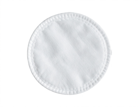 Close-up of a single soft white cotton pad used for skincare and makeup removal on black