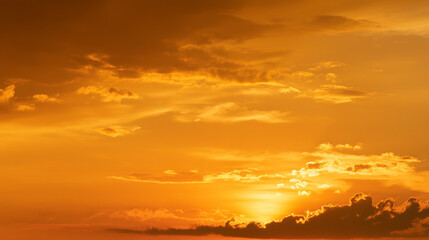 Fototapeta premium Golden orange sky landscape with warm tones and soft clouds. Perfect for nature, sunset, sunrise, and atmospheric backgrounds evoking calm, beauty, and inspiration.