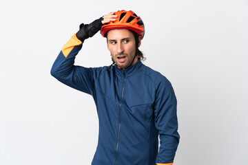 Young cyclist man isolated on white background doing surprise gesture while looking to the side