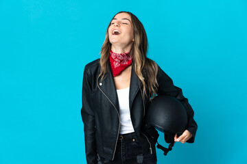 Romanian woman holding a motorcycle helmet isolated on blue background laughing