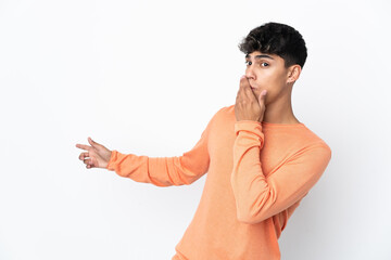 Obraz premium Young man over isolated white background with surprise expression while pointing side