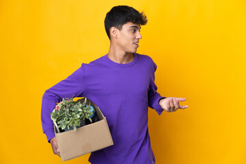 Man making a move while picking up a box full of things with surprise expression while looking side