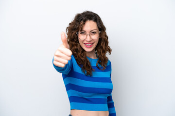 Young caucasian woman isolated on white background with thumbs up because something good has...