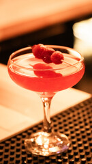 Raspberry cocktail fully prepared on a bar counter.