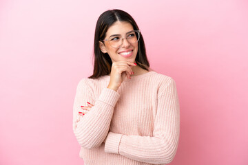 Young Italian woman isolated on pink background With glasses and thinking while looking up