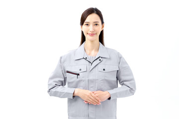 両手を前に置く作業員　あいさつする作業服の女性
