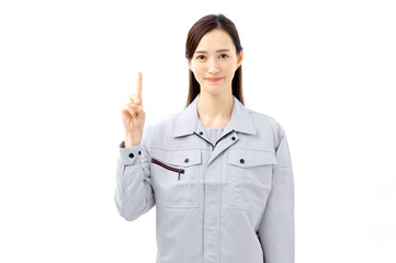 指差しポーズをする作業服の女性　説明