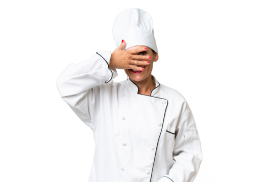 Middle-aged chef woman over isolated background covering eyes by hands and smiling