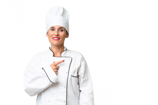Middle-aged chef woman over isolated background pointing to the side to present a product - Powered by Adobe
