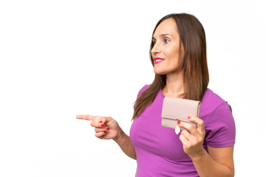 Middle-aged caucasian woman holding a wallet over isolated background pointing to the side to present a product