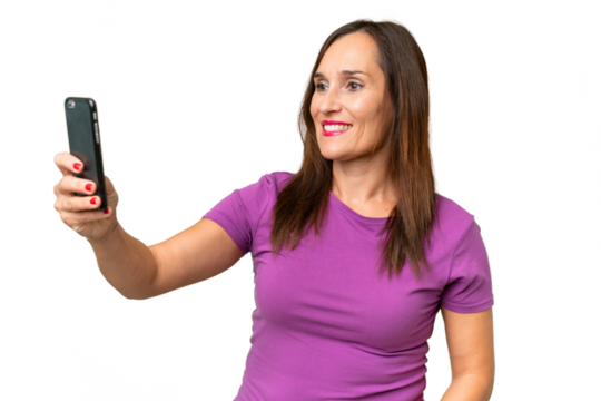 Middle-aged caucasian woman over isolated background making a selfie with mobile phone - Powered by Adobe