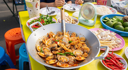 A stir-fried surf clams with chili Paste in a wok pan.