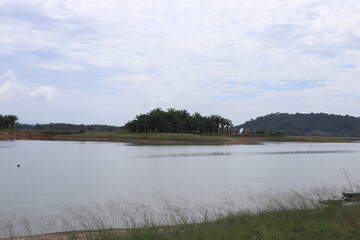Serene Waterscape Depicting an Island Sanctuary Nestled Amidst Rolling Hills and Overcast Skies