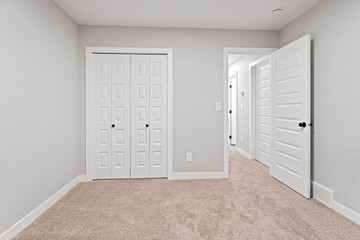 White bedroom with a white door and a white closet