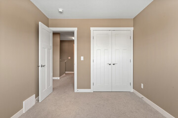 White bedroom with a white door and a white closet