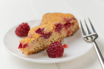 Slice of Raspberry Cake on White Plate with Fork and Fresh Berries on Light Background
