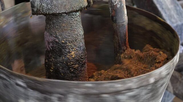 A traditional method of oil extraction, likely using a wood-pressed oil mill also known as a chekku or ghani