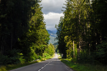Long straight road through the mountains from drivers perspective