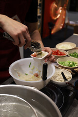 chef elaborando aperitivos con varios ingredientes con una pinza y sus manos