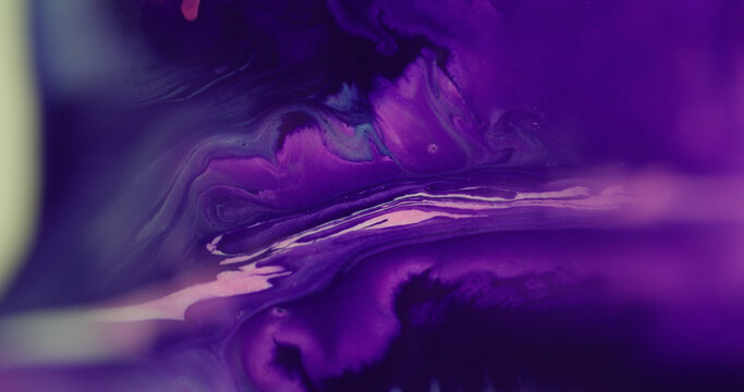 Paint spatter. Drip liquid. Defocused purple pink neon color splash dark black blotch spreading water on abstract acrylic background.