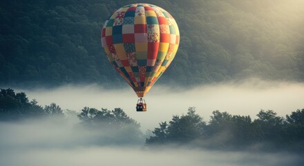 Fototapeta premium Colorful hot air balloon floats above misty forest