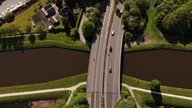 Cars crossing bridge over river in rural landscape