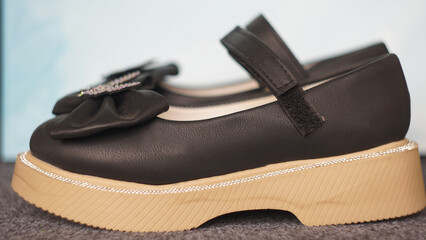 Girls' shiny black shoes on the carpet