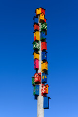 Very colorful bird boxes on a long pole