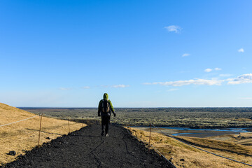 Woman hiking through the Icelandic nature at the Fjadrargljufur canyon